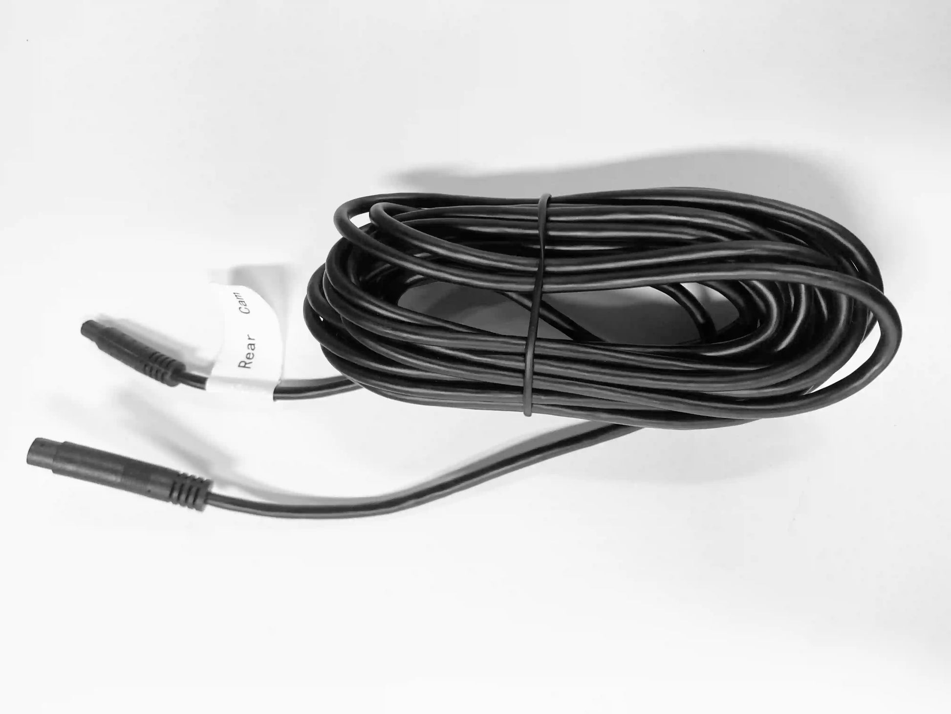 Coiled black cable with connectors on a white background